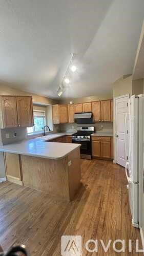 A kitchen with wooden cabinets and a white refrigerator.