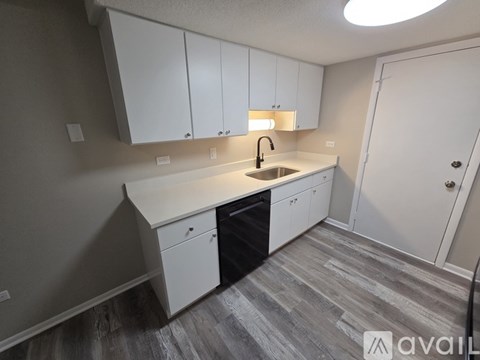 A kitchen with white cabinets and a sink.