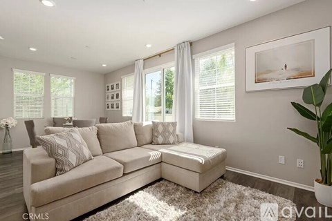 A living room with a large couch and a picture on the wall.