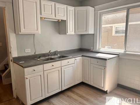A kitchen with white cabinets and a dark countertop.