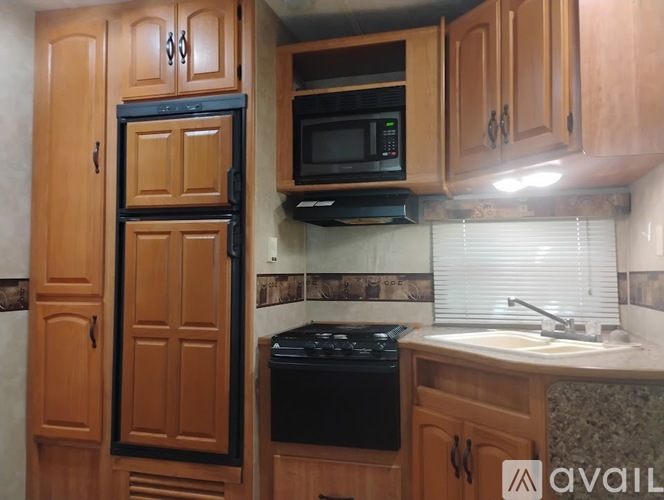 A kitchen with wooden cabinets and a black stove top oven.