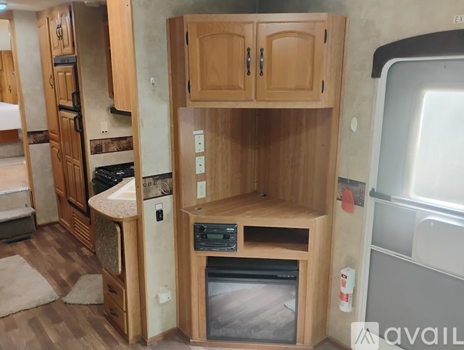 A wooden entertainment center with a television and DVD player in a kitchen.