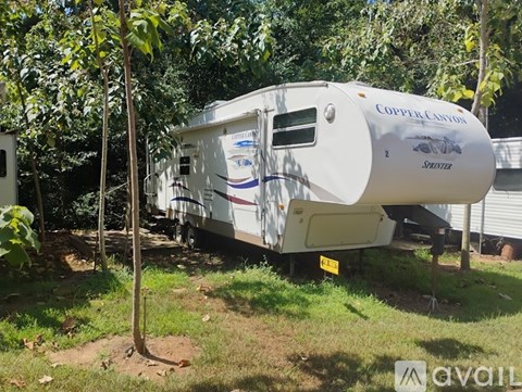 A white RV with the words "Copper Canyon" on the side is parked in a grassy area.