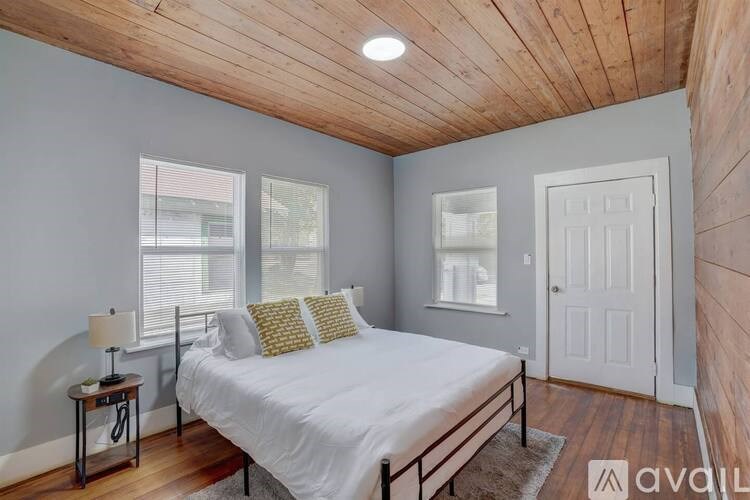 A bedroom with a bed, nightstand, and window.