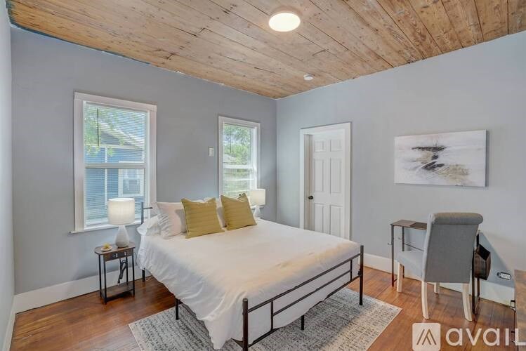 A bedroom with a bed, desk, and chair.