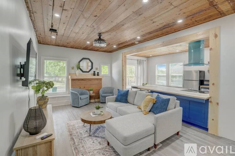 A living room with a white couch and a wooden ceiling.