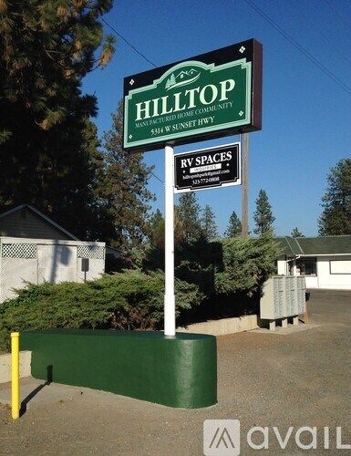 A sign for Hilltop RV Spaces is displayed in front of a building.