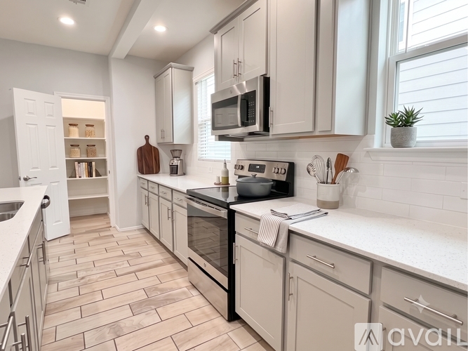 A kitchen with a white countertop and a stainless steel refrigerator.
