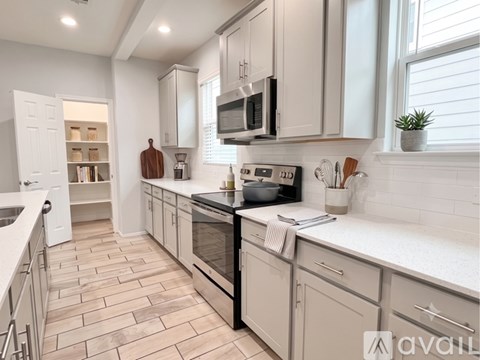 A kitchen with a white countertop and a stainless steel refrigerator.