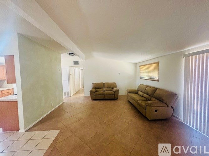 A living room with a brown sofa and a white rug.
