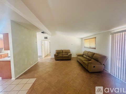 A living room with a brown sofa and a white rug.