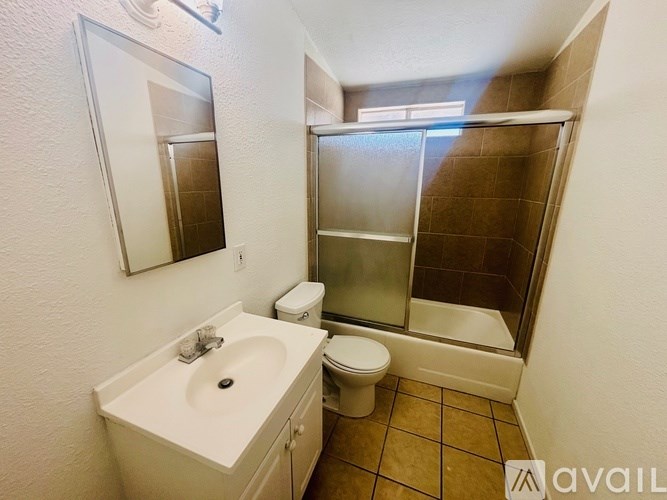 A bathroom with a toilet, sink, and shower.
