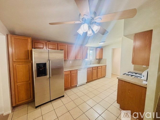 A kitchen with a refrigerator, stove, and cabinets.