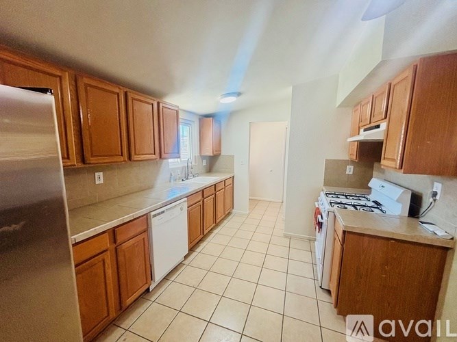 A kitchen with wooden cabinets and a stainless steel refrigerator.