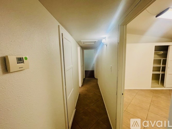 A long hallway with a light on the ceiling and a door on the right.