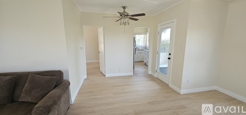 A living room with a brown couch and a ceiling fan.
