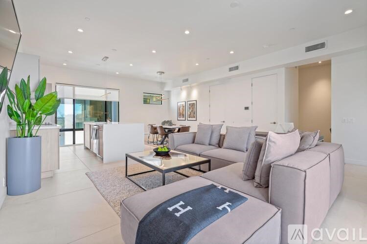 A modern living room with a grey sofa and a glass coffee table.