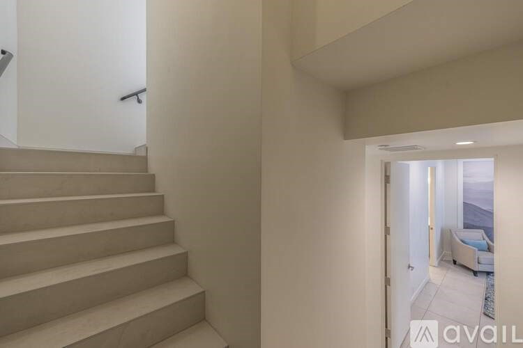 A staircase in a modern home leading to a living room.