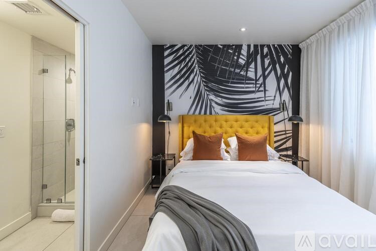 A bedroom with a large bed and a yellow headboard.