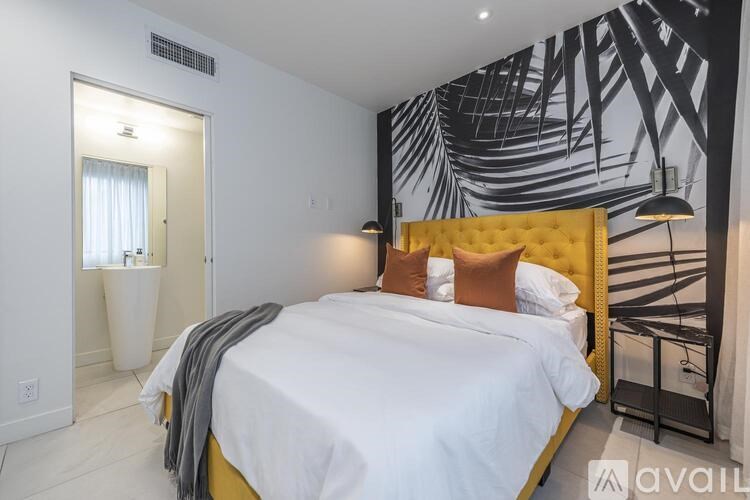 A bedroom with a white bed and a yellow headboard.