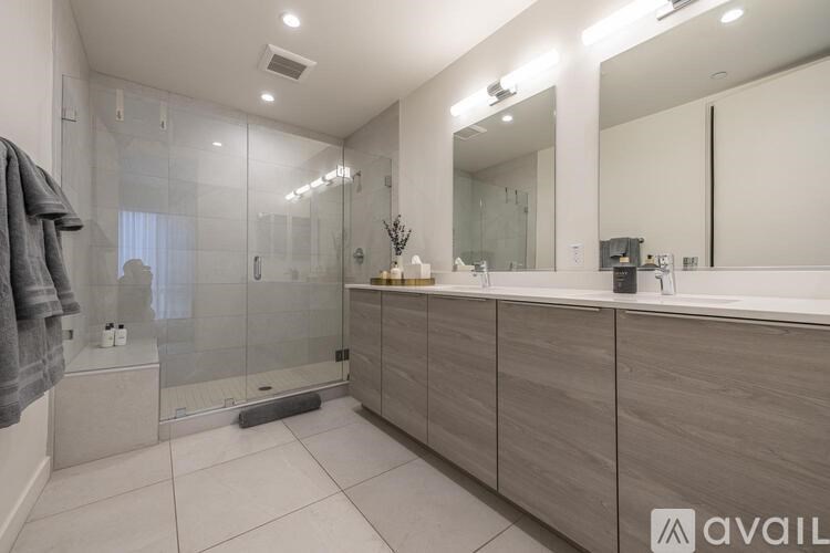 A modern bathroom with a walk-in shower and double vanity sinks.