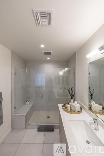 A modern bathroom with a walk-in shower and double sink vanity.