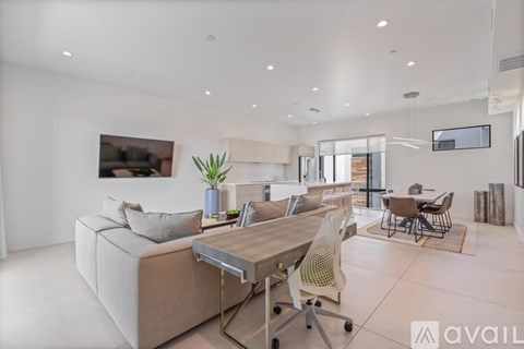 A modern living room with a large couch and a dining table.
