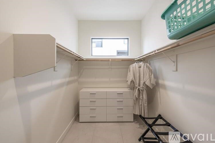 A laundry room with a washer and dryer, a basket, and a towel hanging up.