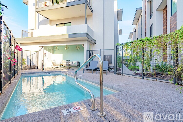 A pool with a 3 people maximum sign in front of a building.