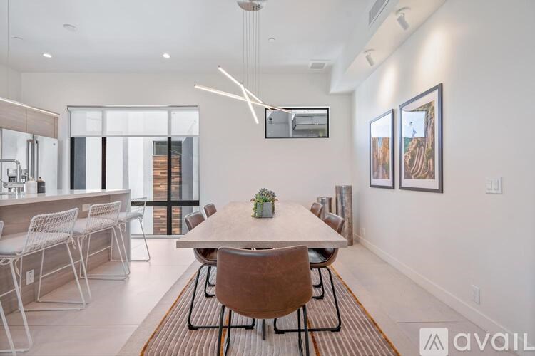 A modern dining room with a wooden table and chairs.