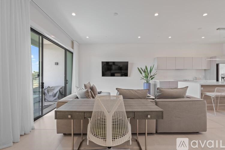 A modern living room with a white chair and a grey sofa.