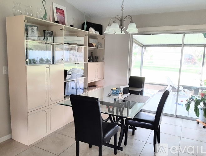 A dining area with a glass table and chairs.
