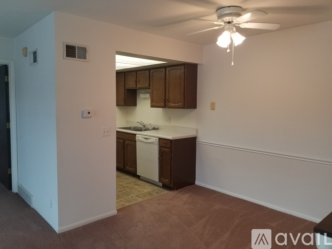 A kitchen area with brown cabinets and a white dishwasher.