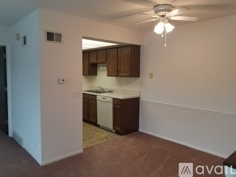 A kitchen area with brown cabinets and a white dishwasher.