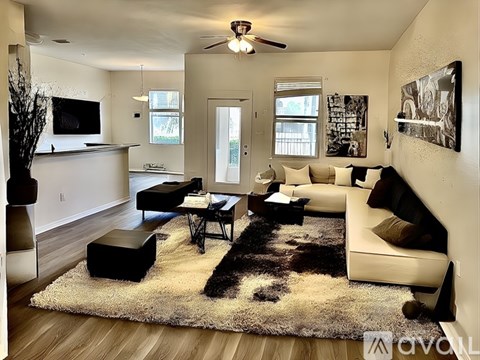 A living room with a black and white cowhide rug in the center.