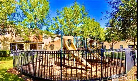 A playground with a slide and a fence.