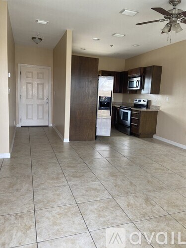 A kitchen with a white door and a ceiling fan.