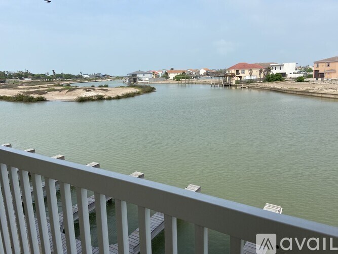 A view from a balcony overlooking a body of water with buildings in the distance.