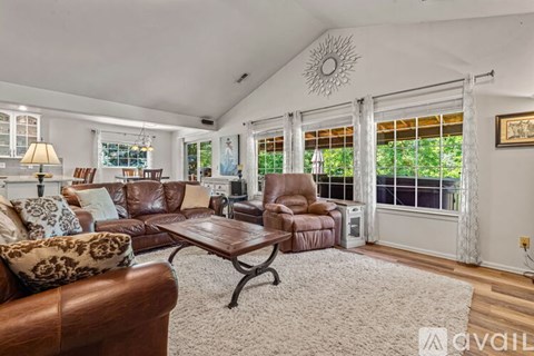 A living room with a brown leather couch and a wooden coffee table.