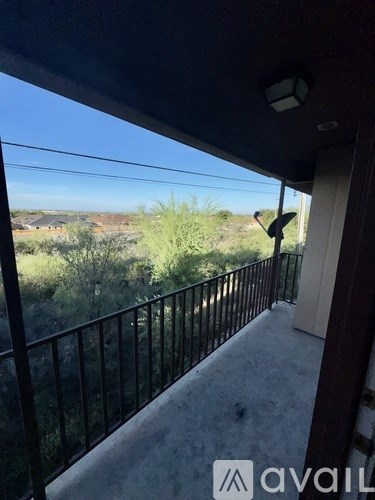 A balcony with a metal railing and a view of the outdoors.