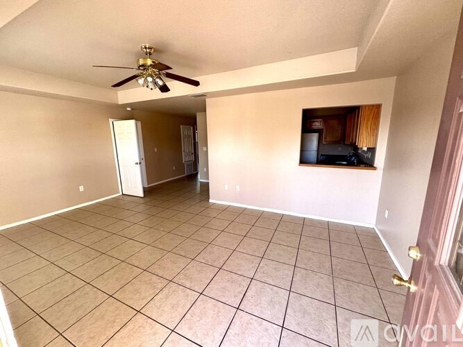 A living room with a ceiling fan and a television.