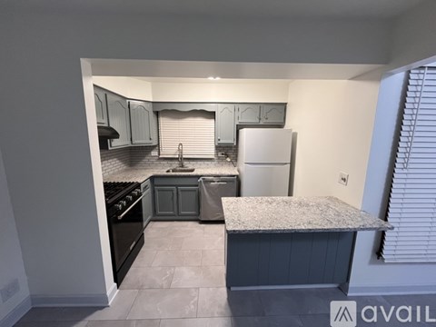 A kitchen with a black stove top oven and a white refrigerator.