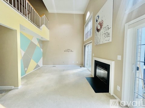 A spacious living room with a fireplace and a painting on the wall.