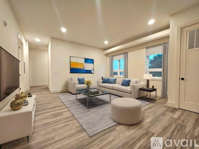 A living room with a white couch, a coffee table, and a painting on the wall.