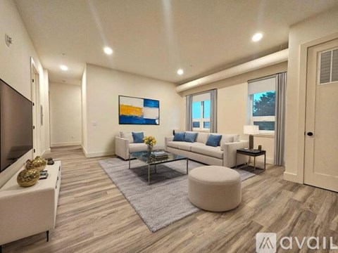 A living room with a white couch, a coffee table, and a painting on the wall.