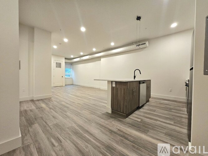 A spacious kitchen with wooden flooring and a central island.