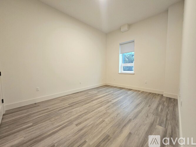 A room with wooden flooring and a window.