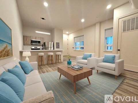 A living room with a white couch, a coffee table, and a painting on the wall.