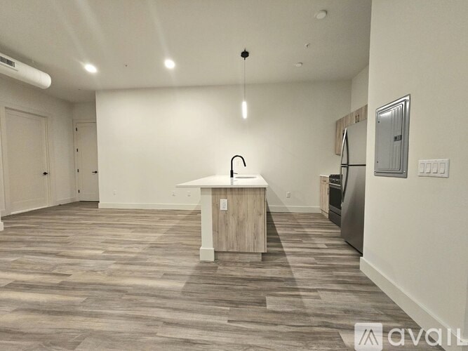 A kitchen area with a wooden island and a refrigerator.