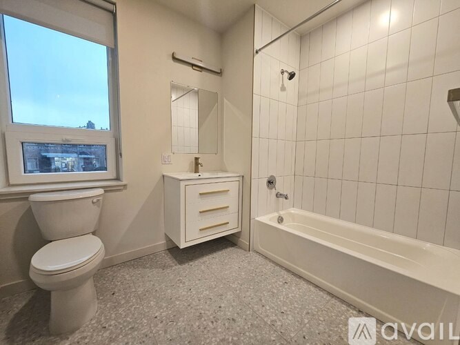 A bathroom with a toilet, a tub, and a window.